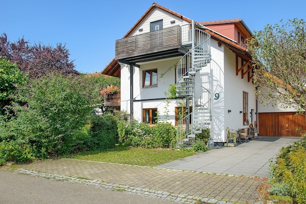 A two-story house with a balcony, a staircase, and a garage.