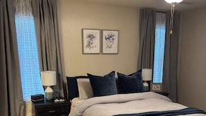 A bedroom with a bed, two bedside tables with lamps, a ceiling fan, and a patterned rug. - Charming 3BR 2BA 20 min drive to the Masters (Grovetown)