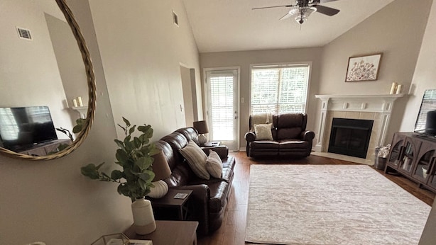 A spacious living room with hardwood flooring, a fireplace, a ceiling fan, and a large mirror. - Charming 3BR 2BA 20 min drive to the Masters (Grovetown)