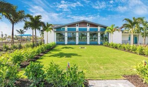 A modern building with a flat roof, large windows, and a well-maintained lawn with a flagpole.