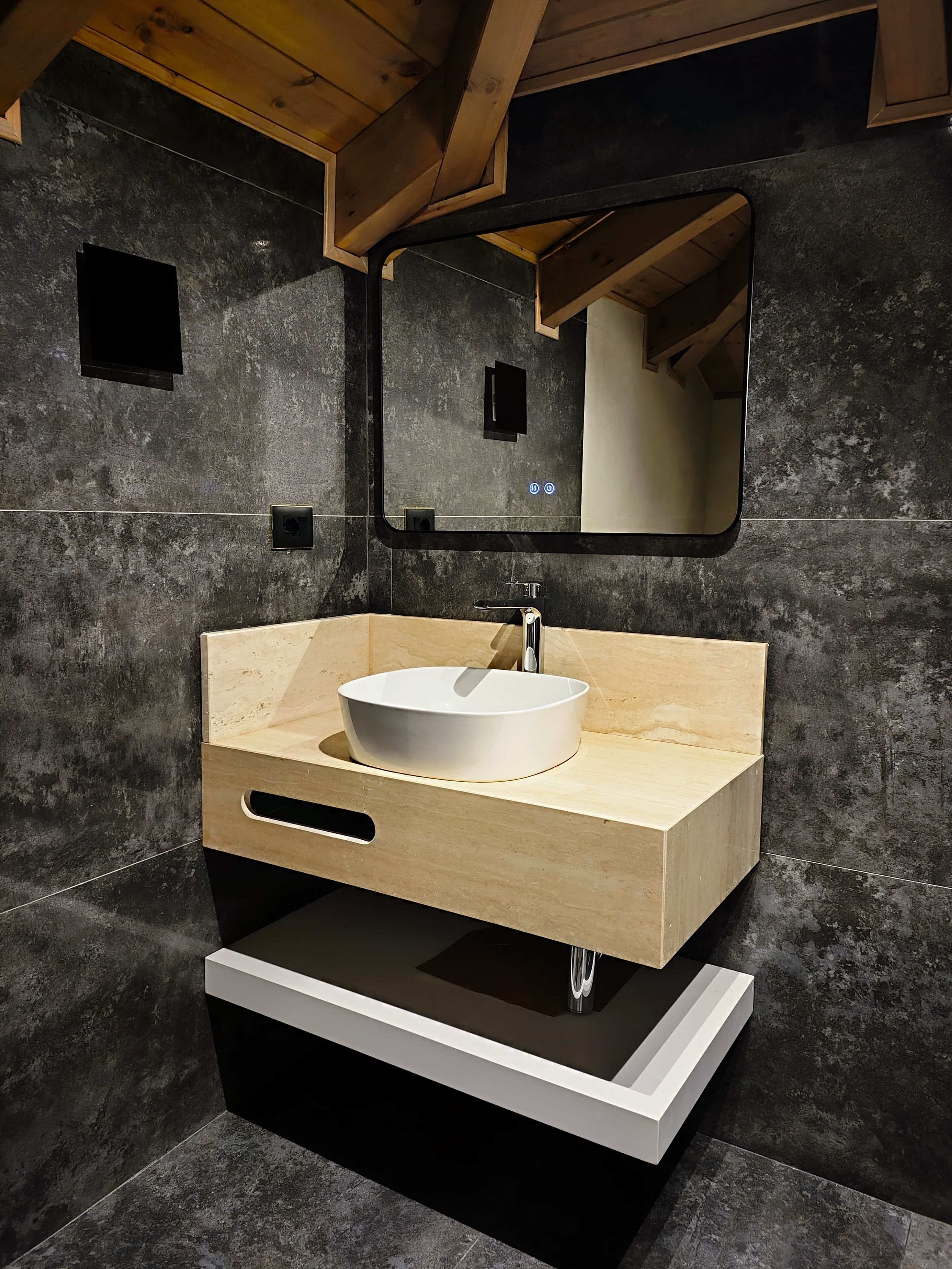 Un bagno moderno con un mobile bagno in legno, un lavandino bianco e uno specchio grande.