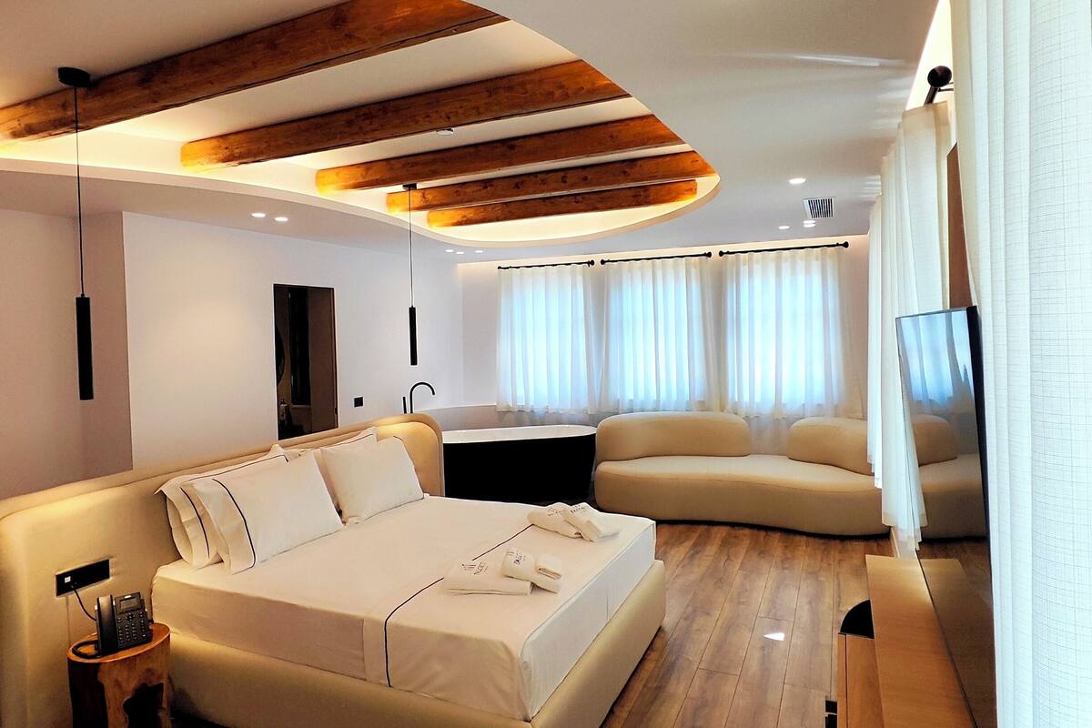 Une chambre d’hôtel moderne avec un grand lit, un canapé et une télévision.