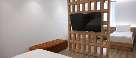 Un dormitorio moderno con un separador de madera, un televisor de pantalla plana, una cama, un banco y una pequeña mesita de noche.