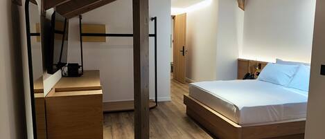 Un dormitorio moderno con cama de madera, un escritorio y un armario.