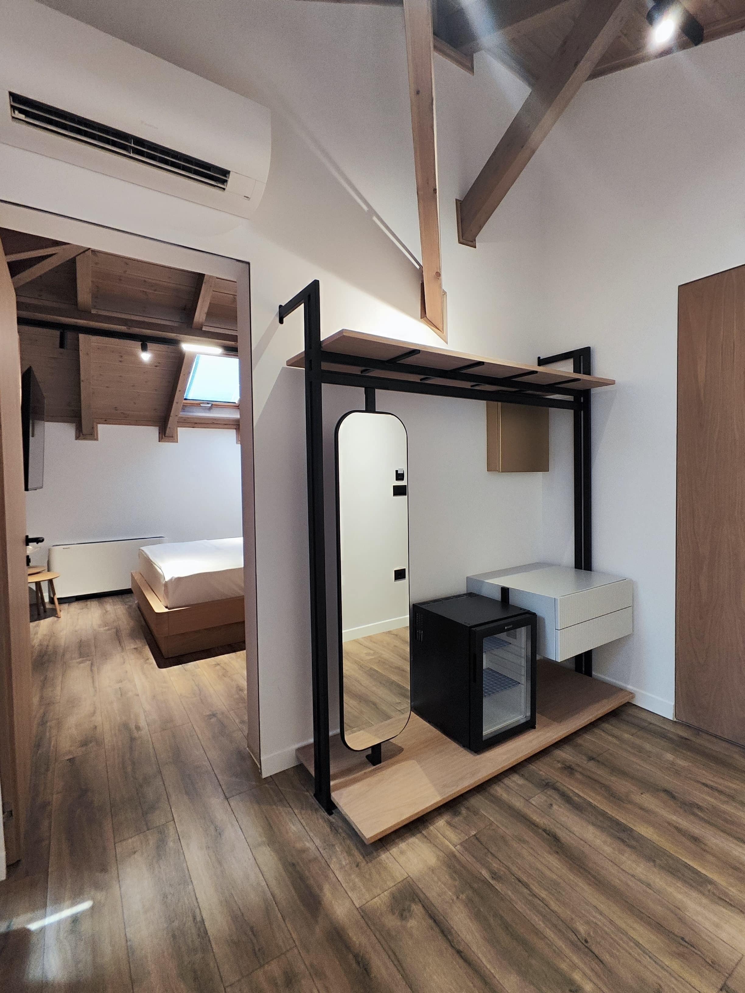 Une chambre moderne et compacte, dotée d’un lit superposé, d’un petit bureau et d’une armoire intégrée.