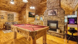 A wooden interior with a pool table, a fireplace, and a Pac-Man arcade. - Kozy Cub Cabin, Gated Resort, Pool Table (Sevier County)