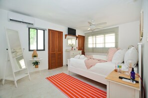 A bedroom with a bed, bedside table, nightstand, and a window with curtains. - Villa 8 M-4
Beautiful Ocean View 2 Bedroom, steps to the private beach (Punta Cana)