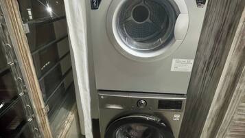 A MIKA front-loading washing machine with a control panel, a smaller front-loading machine below it, and a glass door with a metal handle.
