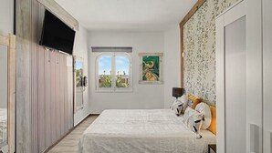 A bedroom with a bed, a window, and a wall with a floral pattern. - Apartment Two Minutes from the Beach. Puerto Rico (Mogán)