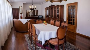 A dining room with a white table, brown chairs, a chandelier, and a wooden cabinet. - Villa 'Casa Dos Leões' with Mountain View, Private Pool and Wi-Fi (Ponte de Lima)