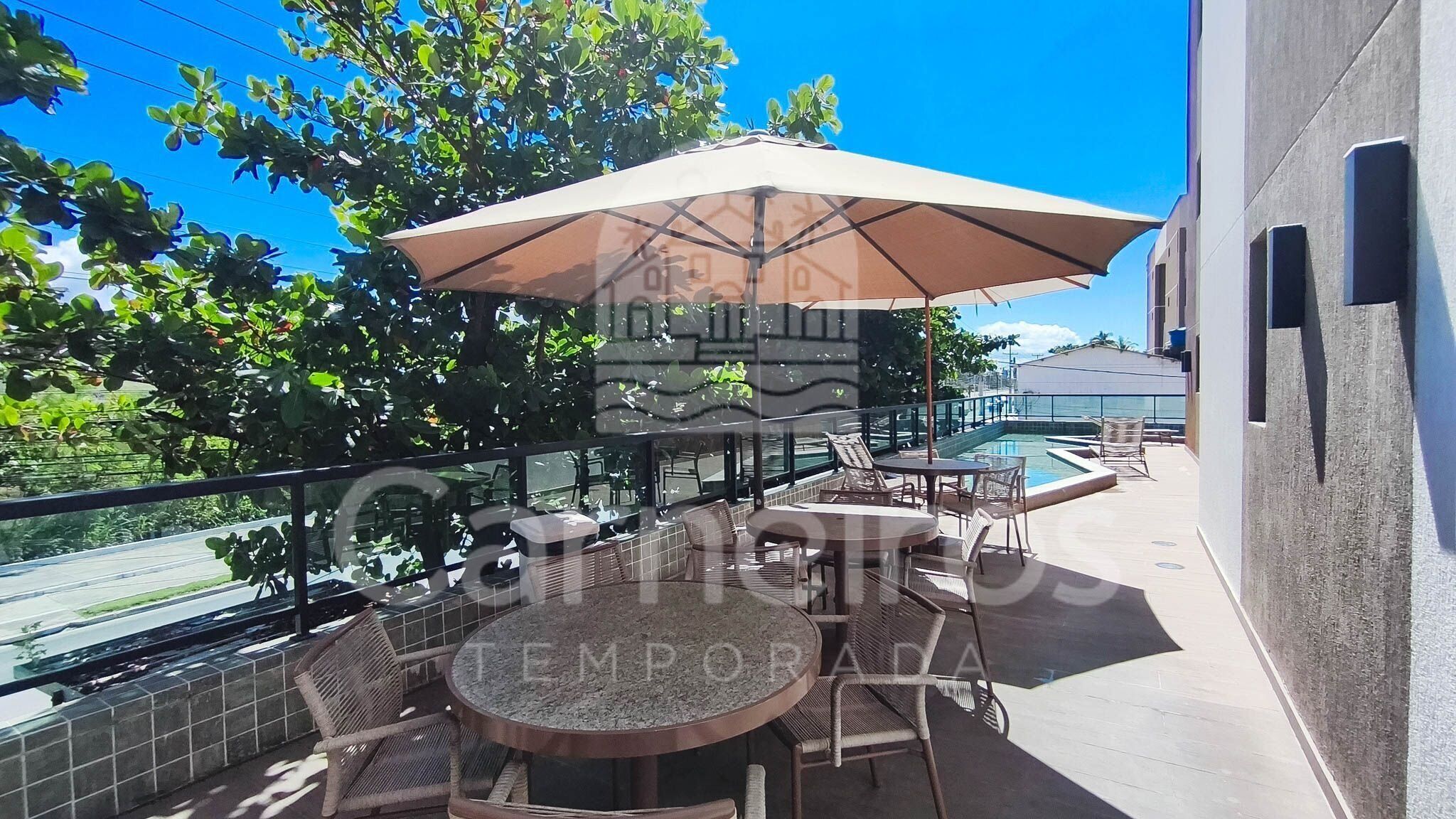 Une terrasse avec piscine, des sièges extérieurs et une vue sur la ville.