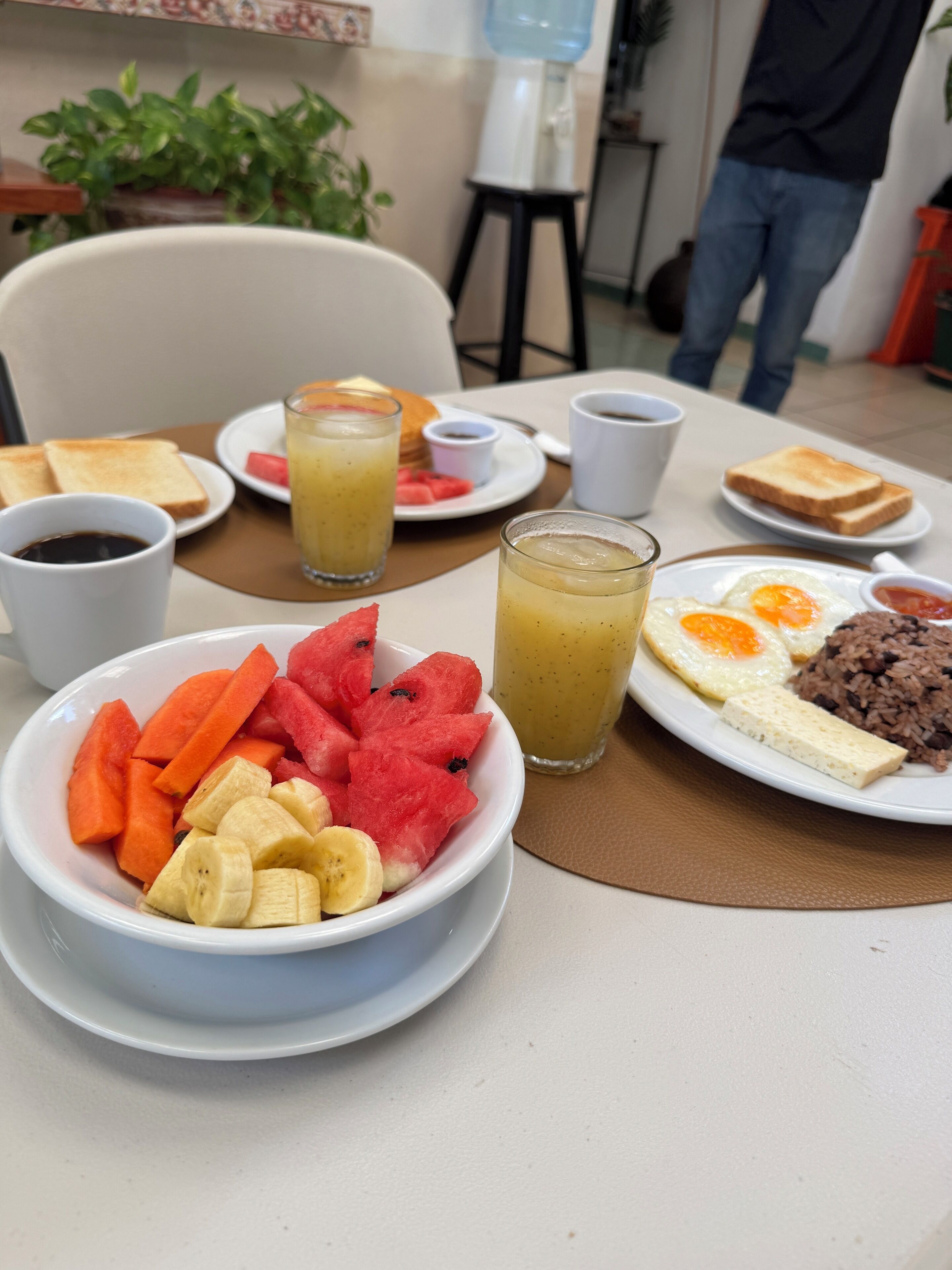 Een ontbijttafel met toast, fruit, eieren en rijst.