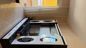 A kitchen with a modern design, featuring two ovens and a built-in microwave. - Apartment with two bedrooms, one with a double bed and one with two beds (Saranda)