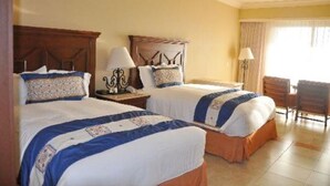 Una habitación de hotel con dos camas, un escritorio y una silla.