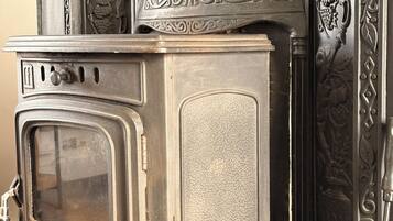 A vintage stove with a large oven door, a control panel with knobs, and decorative metalwork on the upper section.