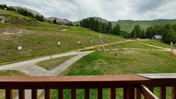 Un espace extérieur agréable, avec un sentier pavé, une pelouse et des montagnes qui se dessinent à l’horizon.