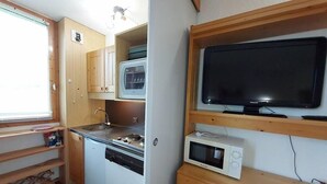 Une cuisine compacte équipée d’une cuisinière, d’un four à micro-ondes et d’un lave-vaisselle.