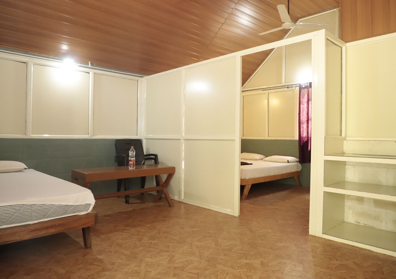 Una habitación con dos camas, un escritorio, una silla y un armario.