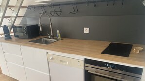 Uma cozinha moderna com máquina de lavar louça embutida, forno e pia.