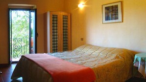 Ein Schlafzimmer mit Bett, Kleiderschrank, Balkon und einem Bild an der Wand.
