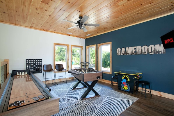 Um quarto com mesa de futebol de mesa, mesa de bilhar e mesa de futebol de mesa com uma placa 'CAMEROUN'.