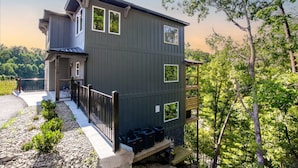 A multi-story building with a balcony, a stone pathway, and a view of trees. - 5BR Retreat Near Dollywood, w Hot Tub & Game Room! (Pigeon Forge)