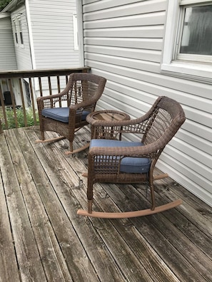 A wooden deck with wicker rocking chairs and a small table. - Kanawha City Home (Charleston)