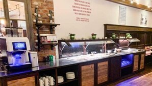 A buffet setup with a coffee machine, a variety of dishes, and a wooden counter. - Brauerei Gasthaus Lohhof (Unterschleißheim)