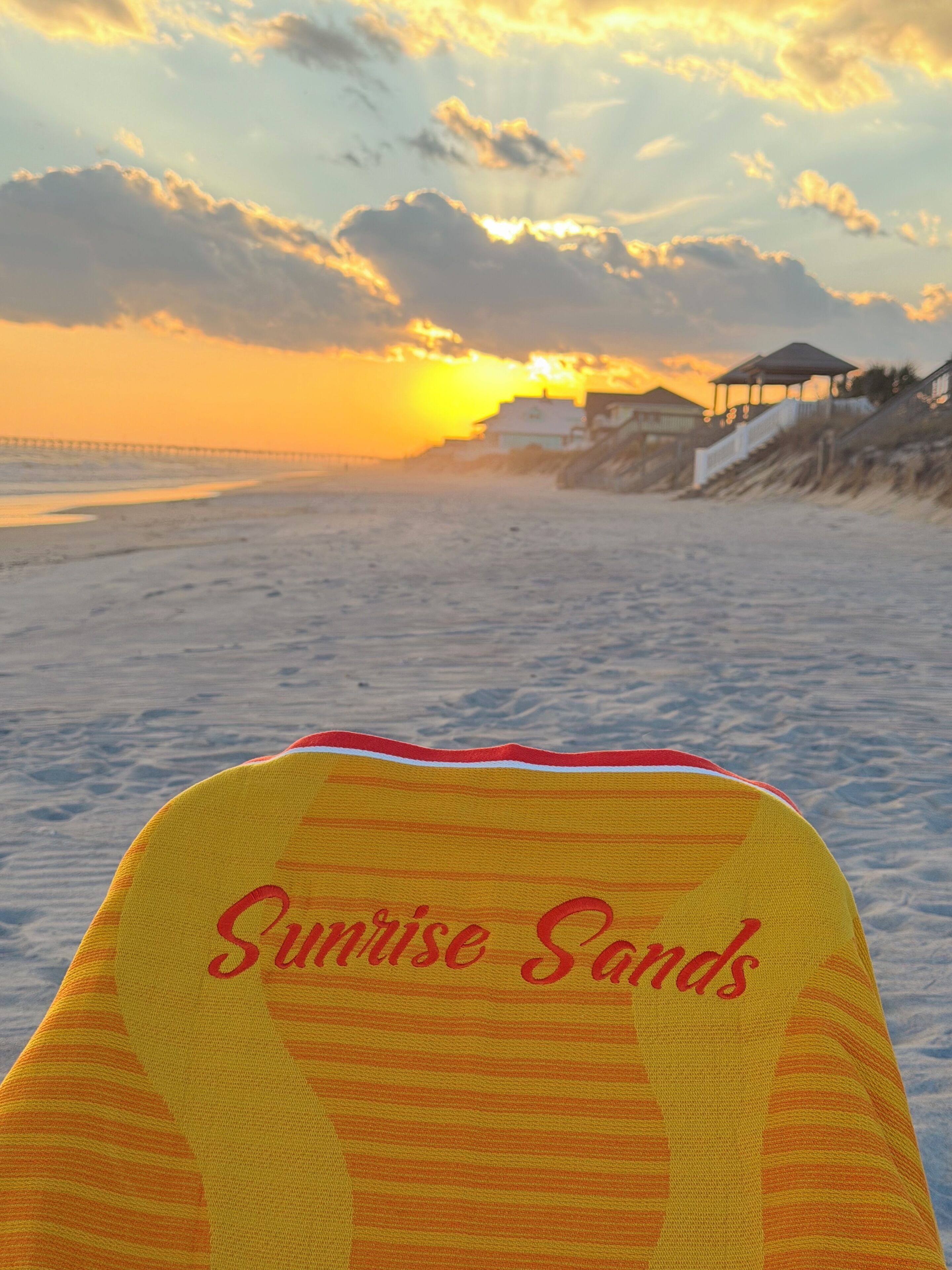 A beach scene with a chair labeled "Sunrise Sands" and a sunset in the background.