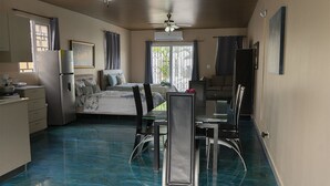 A compact room with a bed, a dining table with chairs, a kitchenette, and a ceiling fan. - Excellent beach apartment with excellent amenities (Provincia de Panamá Oeste)