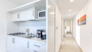 A modern kitchen with white cabinets, a microwave, a coffee maker, and a gas stove. - Apartment 'Unit 1' with Air Conditioning (Ugento)