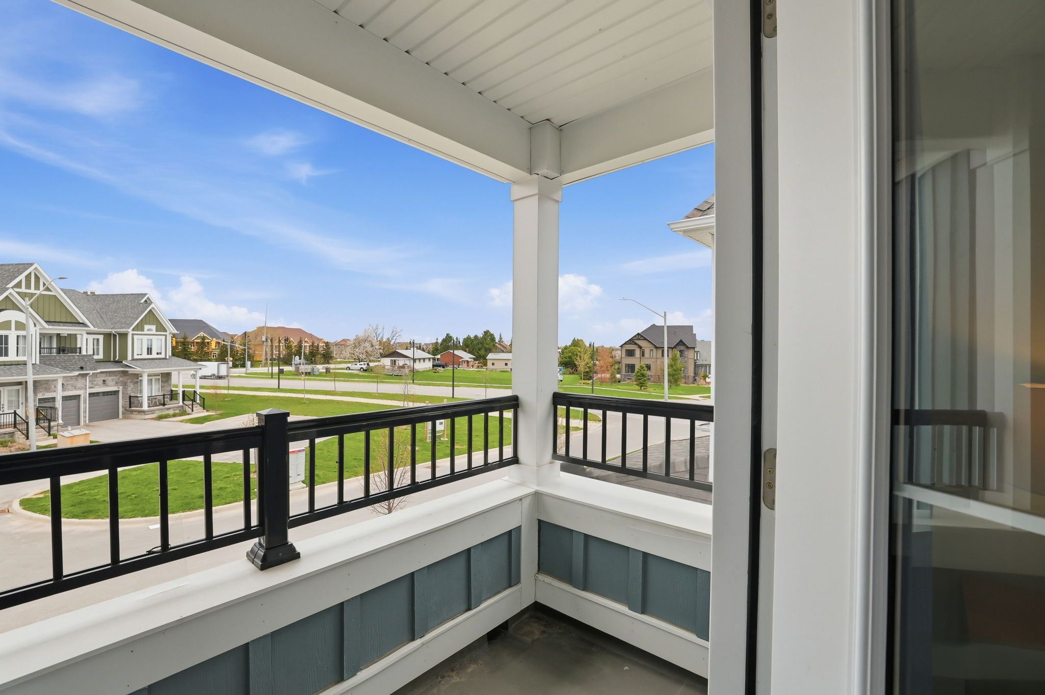 A residential balcony with a view of a suburban neighborhood.