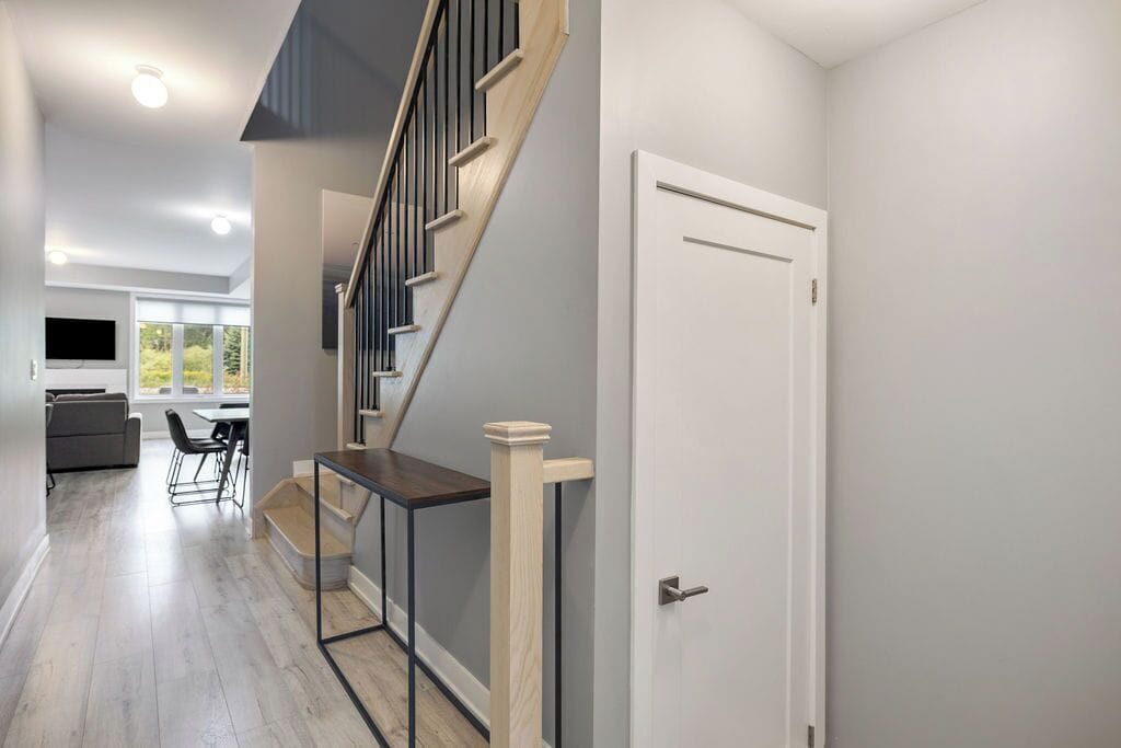 Un intérieur moderne comprenant un escalier, un coin repas et une cuisine.