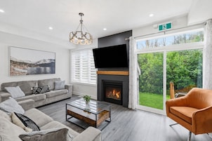 Una sala de estar moderna con chimenea, un sofá, una mesa de centro y un televisor.