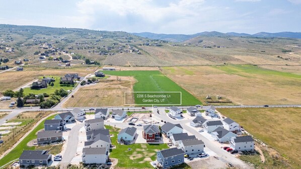 Vista aérea de una zona residencial con casas, carreteras y campos verdes.