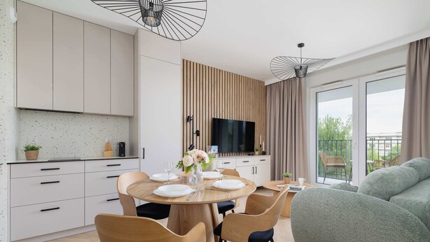 Una cocina moderna con comedor, televisión de pantalla plana y balcón con vistas.
