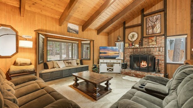 A cozy living room with a fireplace, plush sofas, and a television. - Pine View Escape w/ Hot Tub (Big Bear)