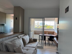 Un apartamento moderno con sofá, mesa de comedor y zona de cocina.