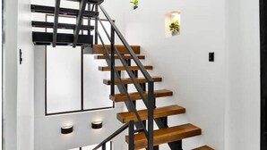 A modern staircase with wooden steps and black metal railings. - Luxury Volcano View! Private Pool & BBQ! (La Fortuna, San Carlos)