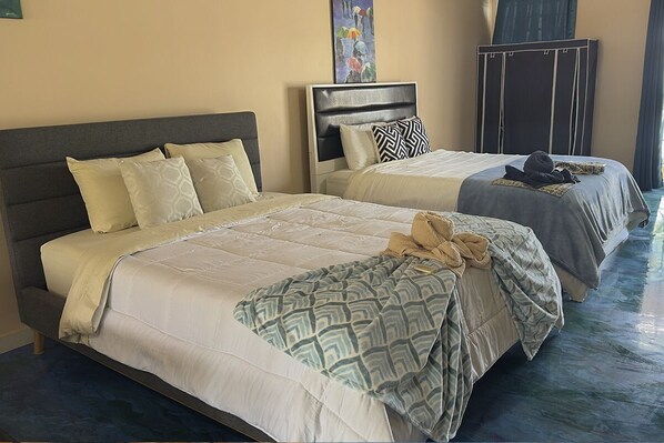 A hotel room with two beds, each with a headboard and multiple pillows. - Great studio apartment on the beach with fantastic amenities (Provincia de Panamá Oeste)