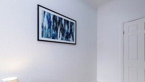 A room with a white door, a framed abstract painting on the wall, and a lamp on the floor. - Preston PR2 Home | Ashton-on-Ribble | Parking (Lancashire)