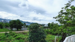 A lush green landscape with a white fence and a staircase leading up. - Kampot Origin Guesthouse (Kampot)