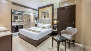 Ein modernes Hotelzimmer mit einem großen Bett, einem Schreibtisch, einem Stuhl, einem Spiegel und einem Kleiderschrank.
