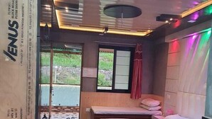 Una habitación de hotel moderna con una cama grande, una mesita pequeña y vistas al exterior.