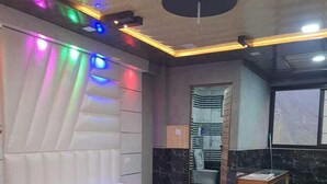 Una habitación de hotel moderna con una cama grande, una mesita de madera y un baño visible a través de una puerta abierta.