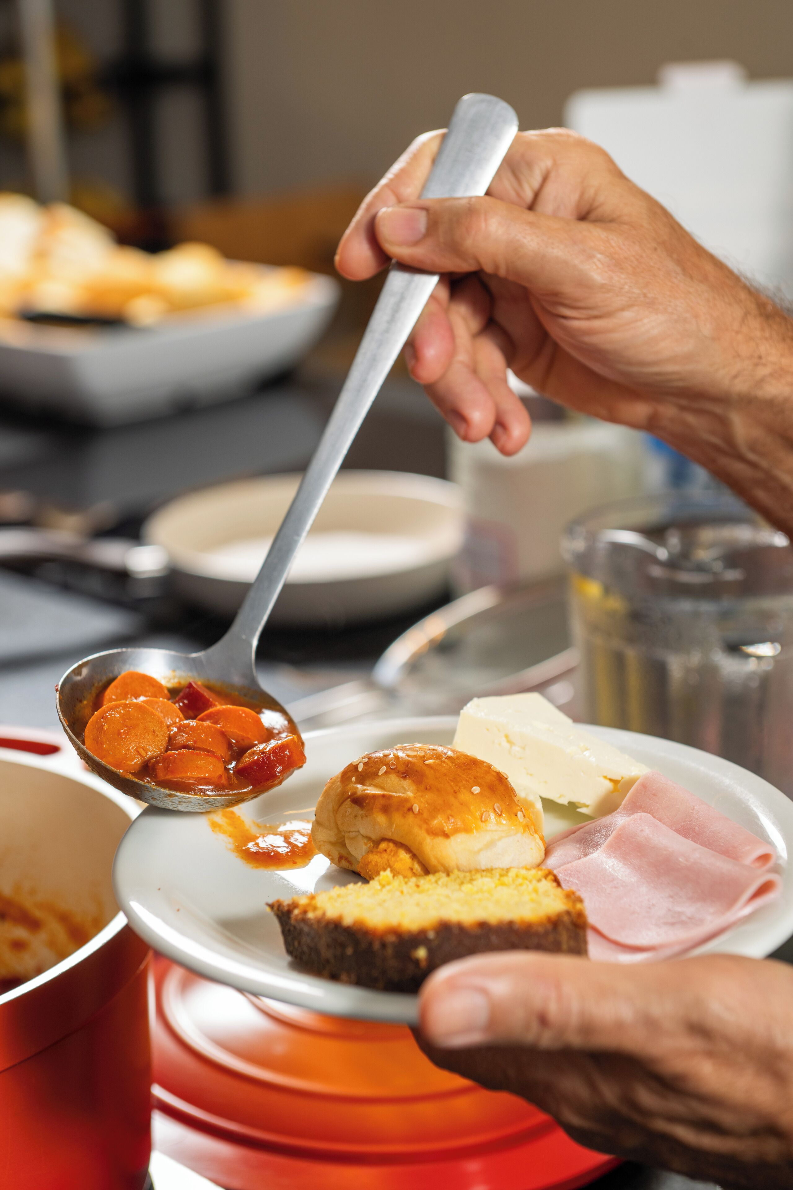 A dining table with various dishes including a plate with a slice of cake, a spoon with food, and a glass of water.