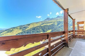 A wooden balcony with a metal railing overlooking a mountainous landscape. - Ski-In Out Mountain Apt with Balcony in Meribel (Méribel)