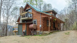 A log cabin with a balcony, a stone chimney, and a gravel driveway. - Mountain Dove Log Cabin Healing Retreat+Mtn Views+Walking trail (Weaverville)