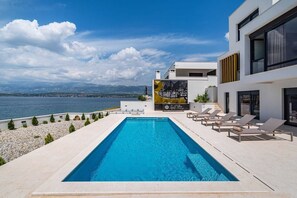 A modern pool area with a clear view of the sea and mountains in the background. - Villa Rosa dei Venti with Pool (Novigrad)