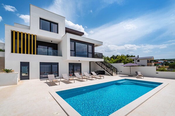 A modern two-story house with a swimming pool, outdoor seating, and a staircase leading to the upper floor. - Villa Rosa dei Venti with Pool (Novigrad)